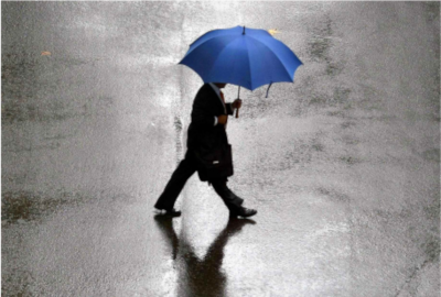 hombre caminando con un paraguas azul